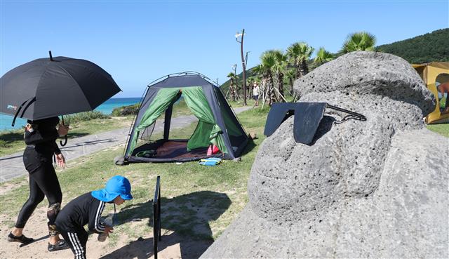 제주 지역 낮 최고기온이 36.1도까지 오르며 폭염경보가 발효 중인 13일 오전 제주시 함덕해수욕장에서 피서객들이 여유를 즐기고 있다.2020.8.13 뉴스1