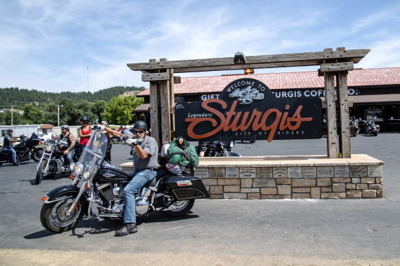 A biker poses for a photo in front of the Sturgis welcome sign during the 80th annual Sturgis Motorcycle Rally on Saturday, Aug. 15, 2020, in Sturgis, S.D. (Amy Harris/Invision/AP)/2020-08-16 12:44:31/ <연합뉴스
