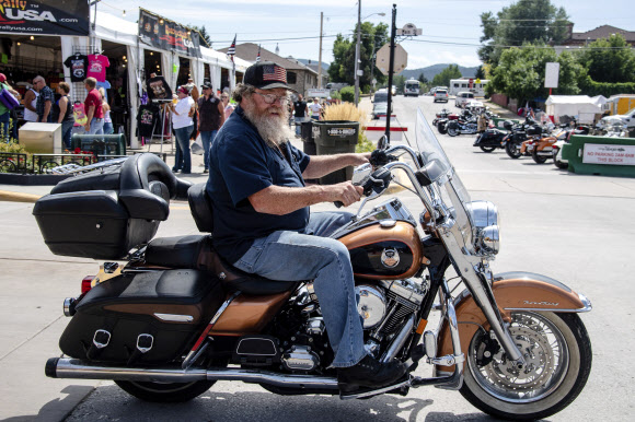 A biker poses for a photo on Main Street during the 80th annual Sturgis Motorcycle Rally on Saturday, Aug. 15, 2020, in Sturgis, S.D. (Amy Harris/Invision/AP)/2020-08-16 12:44:29/ <연합뉴스