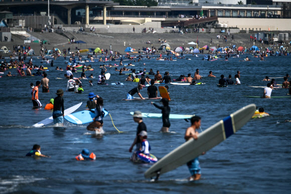 사람들이 15일(현지시간) 일본 가나가와현 후지사와에서 폭염 속 해변 물놀이로 더위를 식히고 있다. AFP 연합뉴스