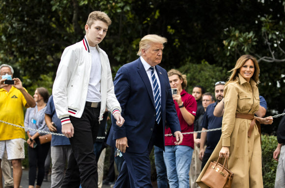 도널드 트럼프 대통령과 멜라니아 여사, 아들 배런 트럼프가 16일(현지시간) 미국 뉴욕주 베드민스터의 주말 여행을 마치고 백악관에 도착해 걸어가고 있다. AP 연합뉴스
