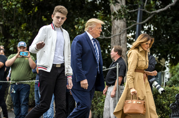 도널드 트럼프 대통령과 멜라니아 여사, 아들 배런 트럼프가 16일(현지시간) 미국 뉴욕주 베드민스터의 주말 여행을 마치고 백악관에 도착해 걸어가고 있다. AP 연합뉴스