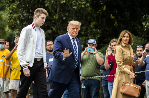 도널드 트럼프 대통령과 멜라니아 여사, 아들 배런 트럼프가 16일(현지시간) 미국 뉴욕주 베드민스터의 주말 여행을 마치고 백악관에 도착해 걸어가고 있다. AP 연합뉴스