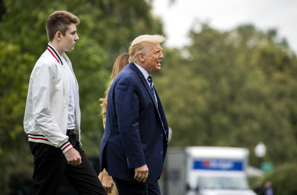 도널드 트럼프 대통령과 멜라니아 여사, 아들 배런 트럼프가 16일(현지시간) 미국 뉴욕주 베드민스터의 주말 여행을 마치고 백악관에 도착해 걸어가고 있다. AP 연합뉴스