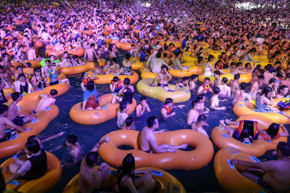 사람들이 15일(현지시간) 중국 후베이성 우한의 한 수영장에서 더위를 식히며 공연을 즐기고 있다. AFP 연합뉴스