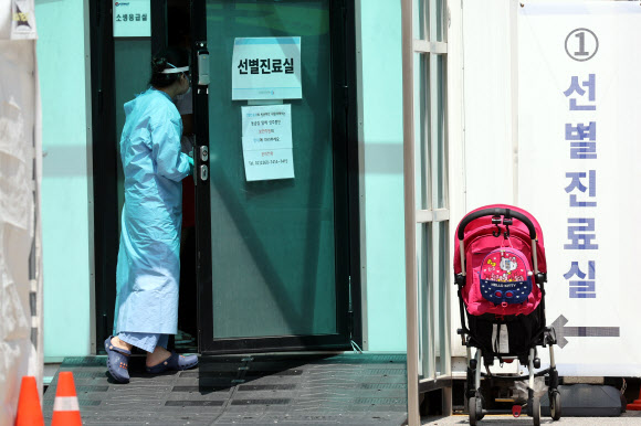 나흘째 세자릿수 코로나19 확진  17일 서울 중구 국립중앙의료원에 마련된 선별진료소에서 의료진이 신종 코로나 바이러스 감염증(코로나19) 검사를 위해 내원객과 함께 진료실 안으로 들어가고 있다.중앙방역대책본부는 이날 0시 기준으로 국내 코로나19 신규 확진자가 197명 늘어 누적 1만5천515명이라고 밝혔다. 2020.8.17<br>연합뉴스