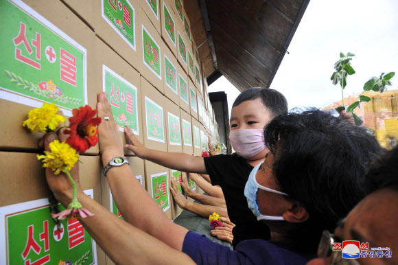 김정은이 보낸 선물박스 만지는 북한 주민들
