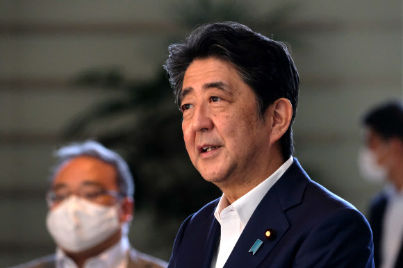 아베 신조(가운데) 일본 총리가 19일(현지시간) 도쿄 총리실에 도착해 언론과 대화를 나누고 있다. AFP 연합뉴스