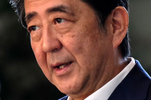 아베 신조 일본 총리가 19일(현지시간) 도쿄 총리실에 도착해 언론과 대화를 나누고 있다. AFP 연합뉴스