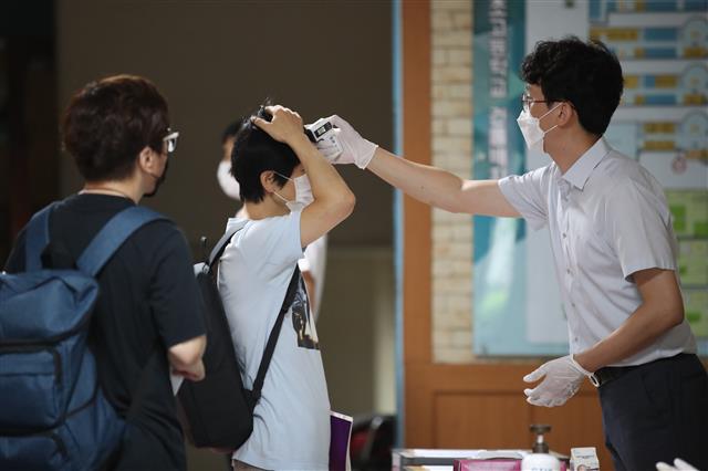 22일 오전 서울 서초구 서초고등학교에서 열린 제38회 법원행정고등고시 제1차 시험에서 응시자들이 체온 측정을 받고 있다. 2020.8.22 뉴스1