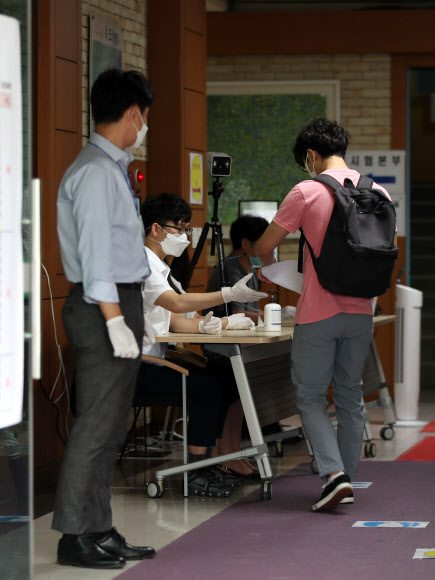 22일 오전 서울 서초고등학교에서 열린 법원행정고등고시 제1차시험에서 수험생들이 발열 확인을 한 뒤 입장하고 있다. 2020.08.22  연합뉴스