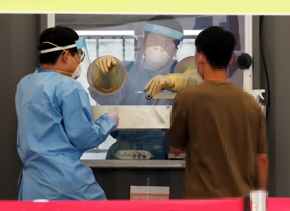 22일 오전 성북구청 앞 바람마당에 설치된 코로나19 선별진료소에서 의료진이 검체 채취를 하고 있다. 2020.8.22  연합뉴스