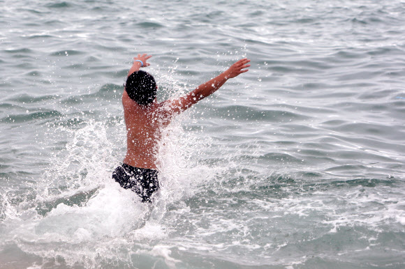 해양수산부가 코로나19 재확산에 따라 전국의 해수욕장을 긴급 폐장하기로 한 22일 강원 강릉 경포해수욕장에서 피서객이 물놀이를 하고 있다. 전국의 해수욕장은 이날 밤 12시부터 긴급 폐장한다. 2020.8.22  연합뉴스