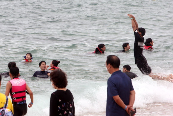 해양수산부가 코로나19 재확산에 따라 전국의 해수욕장을 긴급 폐장하기로 한 22일 강원 강릉 경포해수욕장에서 피서객이 물놀이를 하고 있다. 전국의 해수욕장은 이날 밤 12시부터 긴급 폐장한다. 2020.8.22 연합뉴스