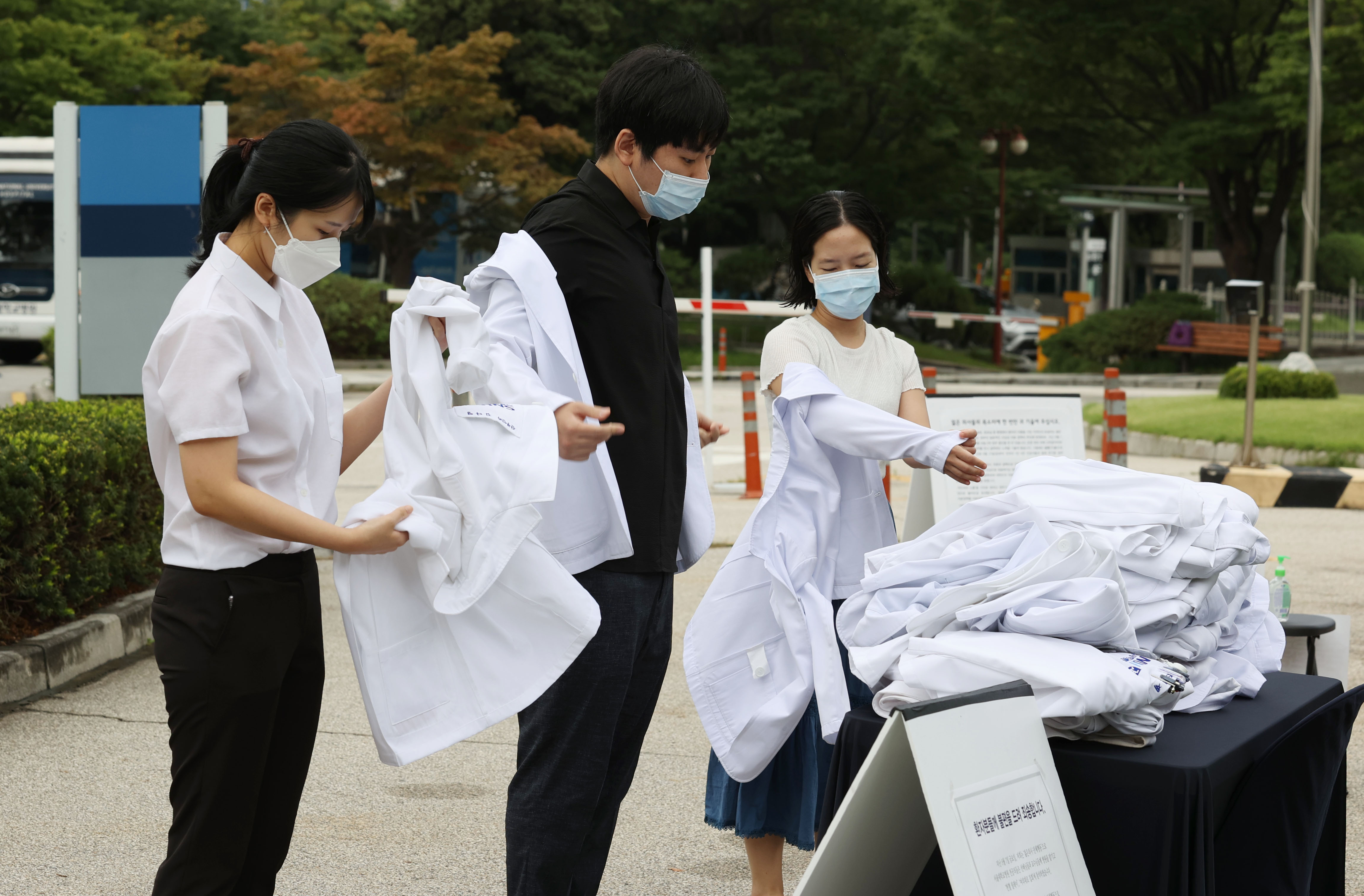 23일 오전 서울 종로구 서울대병원 대학의원 본관 앞에서 정부의 의료정책에 반대하는 전공의들이 의사 가운을 탈의하고 있다. 2020.8.23 연합뉴스