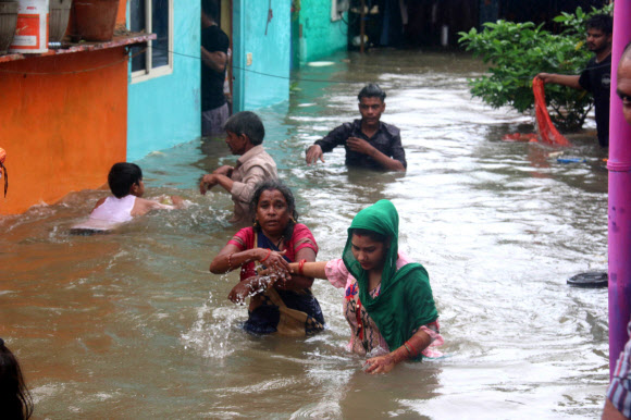 주민들이 22일(현지시간) 인도 보팔에서 폭우가 내려 칼리야소트 강이 위험수위를 넘은 후, 담케다의 침수 지역에서 물 속을 헤치며 다니고 있다. EPA 연합뉴스