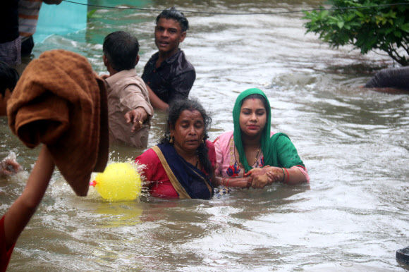 주민들이 22일(현지시간) 인도 보팔에서 폭우가 내려 칼리야소트 강이 위험수위를 넘은 후, 담케다의 침수 지역에서 물 속을 헤치며 다니고 있다. EPA 연합뉴스