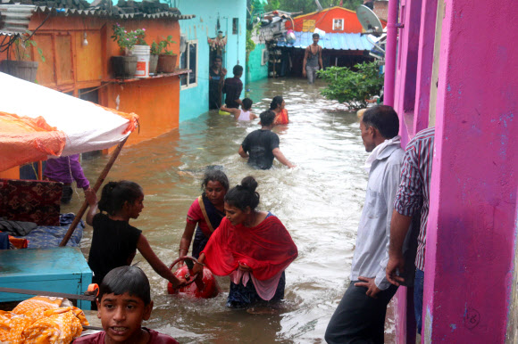 주민들이 22일(현지시간) 인도 보팔에서 폭우가 내려 칼리야소트 강이 위험수위를 넘은 후, 담케다의 침수 지역에서 물 속을 헤치며 다니고 있다. EPA 연합뉴스