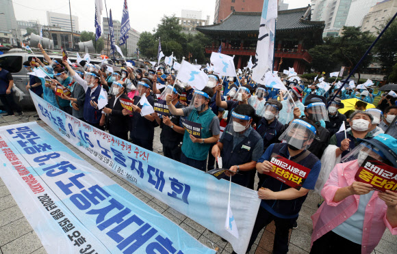 광복절인 지난 15일 서울 종로구 보신각 앞에서 열린 ‘민주노총 8·15 노동자대회’에서 참가자들이 한반도기를 흔들고 있다. 연합뉴스