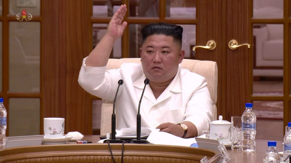 북한 김정은 국무위원장이 지난 25일 노동당 정치국 회의를 열고 태풍과 신종 코로나바이러스 감염증(코로나19) 확산에 대한 대책을 논의했다고 26일 조선중앙TV가 보도했다. 김 위원장이 오른손을 들고 의사 표시를 하고 있다. 2020.8.26  조선중앙TV 화면
