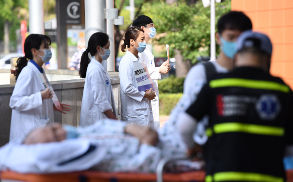 전국의사 2차 총파업 첫날인 26일 가톨릭대학교 서울성모병원에서 전공의들이 요양병원으로 이송되는 환자 뒤로 피켓시위를 하고 있다. 2020.8.26 오장환 기자 5zzang@seoul.co.kr