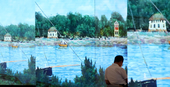 26일 서울 강남구 스타필드 코엑스몰 기둥에 설치된 디지털 사이니지(디지털 디스플레이 광고판)를 통해 인상주의 화가 작품이 영상 콘텐츠로 전시되고 있다.   스타필드 코엑스몰은 디지털 사이니지 론칭을 기념해 ‘큐브나인 미디어아트전’을 진행한다.  사진은 이날 기둥 사이에서 휴식을 취하는 시민. 2020.8.26  연합뉴스