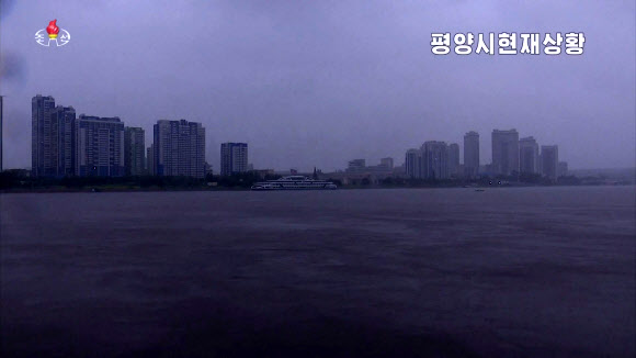 북한 조선중앙TV는 27일 오전 7시30분 평양 대동강 능라도에 아나운서를 연결해 가로수들이 뿌리째 뽑힐듯 흔들리고 강 수위가 높아졌다고 보도했다. 사진은 제8호 태풍 ‘바비’ 북상에 물이 불어난 대동강 일대.2020.8.27  조선중앙TV 화면 