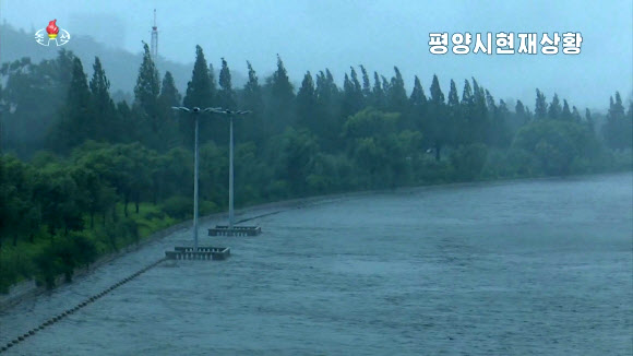 북한 조선중앙TV는 27일 오전 7시30분 평양 대동강 능라도에 아나운서를 연결해 가로수들이 뿌리째 뽑힐듯 흔들리고 강 수위가 높아졌다고 보도했다. 사진은 제8호 태풍 ‘바비’ 북상에 물이 불어난 대동강 일대.  2020.8.27  조선중앙TV 화면
