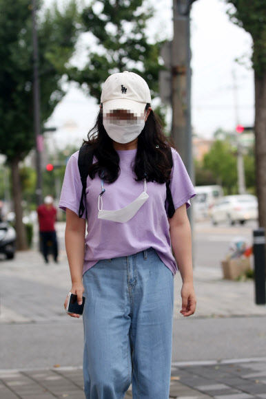 코로나19 집단 감염이 확산일로인 27일 오전 광주 북구 두암동 한 거리에서 마스크를 쓴 시민이 여분의 마스크를 목에 걸고 길을 지나고 있다. 2020.8.27  연합뉴스