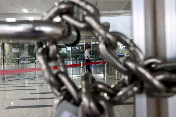 국회 출입 기자의 신종 코로나바이러스 감염증(코로나19) 확진 판정으로 27일 오전 국회 본관이 폐쇄돼 출입구가 쇠사슬로 굳게 잠겨 있다. 2020.8.27  연합뉴스