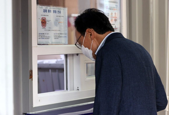 더불어민주당 이해찬 대표가 27일 오후 서울 영등포보건소 선별진료소에서 코로나19 감염 검사 전 문진표를 작성하고 있다. 전날 민주당 최고위원회의를 취재했던 기자가 확진 판정을 받으면서 같은 장소에 있었던 이 대표도 검사 대상으로 분류됐기 때문이다. 2020.8.27  연합뉴스