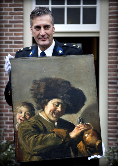 지난 26일(이하 현지시간) 세 번째로 도둑 맞은 네덜란드 거장 프란스 할스의 그림 ‘웃는 두 소년’이 두 번째로 리에르담 미술관에서 도난 당했다가 6개월 뒤 되찾았는데 경찰 관계자가 2011년 11월 3일 소개하고 있다. AFP 자료사진 연합뉴스 