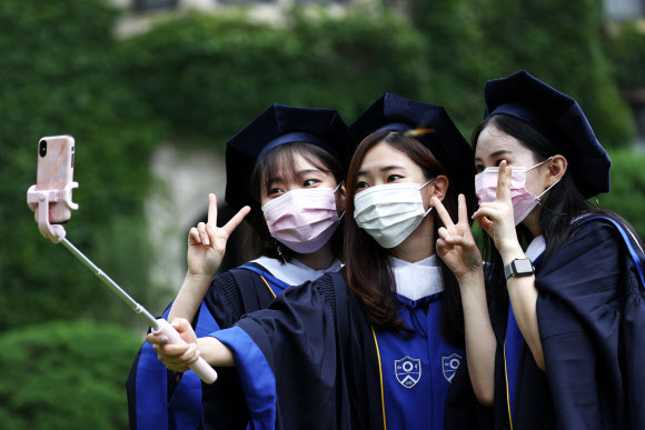 28일 졸업사진 촬영을 위한 가운 대여 행사가 열린 서대문구 연세대학교에서 졸업생들이 마스크를 쓴 채 기념사진을 찍고 있다. 2020.8.28  연합뉴스