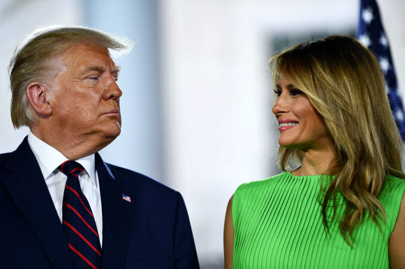 도널드 트럼프 미국 대통령과 부인 멜라니아 여사가 공화당 전당대회 나흘째 마지막 날인 27일(현지시간) 대선후보 수락 연설을 하기 위해 워싱턴 백악관 사우스론(잔디밭)에 마련된 무대 위에서 미소짓고 있다. AFP 연합뉴스