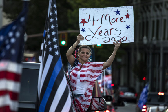 도널드 트럼프 대통령의 지지자들이 20일(현지시간) 미국 오레주 클라카마스에서 포틀랜드까지의 집회와 자동차 퍼레이드 도중 재선을 호소하는 팻말을 들고 있다. AP 연합뉴스
