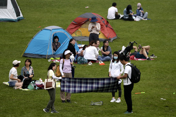 사람들이 30일(현지시간) 중국 베이징 외곽 옌칭의 한 경치 좋은 산에서 피크닉과 캠핑하며 즐거운 시간을 보내고 있다. 중국 본토에서는 이날 현재 보름째 신종 코로나바이러스 감염증(코로나19) 신규 확진자가 1명도 발생하지 않았다. AP 연합뉴스