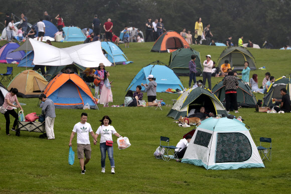 사람들이 30일(현지시간) 중국 베이징 외곽 옌칭의 한 경치 좋은 산에서 피크닉과 캠핑하며 즐거운 시간을 보내고 있다. 중국 본토에서는 이날 현재 보름째 신종 코로나바이러스 감염증(코로나19) 신규 확진자가 1명도 발생하지 않았다. AP 연합뉴스