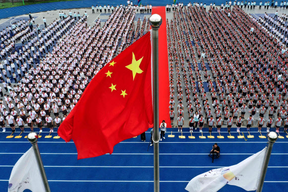 초등학생들이 1일(현지시간) 중국 랴오닝성 선양에서 신학기 첫날 국기게양식에 참여하고 있다. AFP 연합뉴스