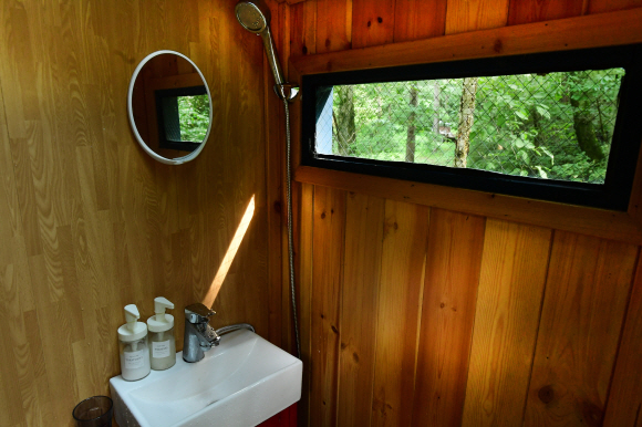 숲을 보며 샤워할 수 있는 화장실 모습이다.