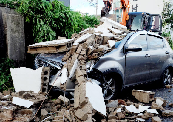 무너진 담벼락에 파손된 차량