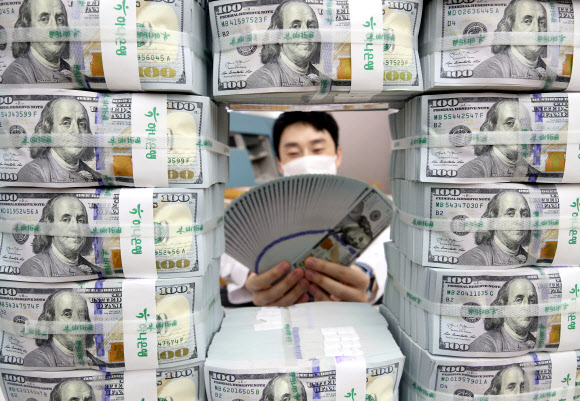 서울 중구 하나은행 본점에서 한 직원이 미국 달러 지폐의 위변조 여부를 들여다보고 있다. 연합뉴스