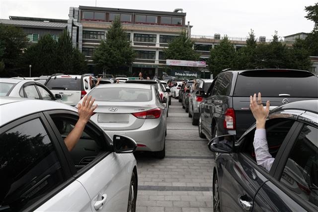 서울씨티교회 신자들이 6일 오전 서울 중랑구 교회 인근 고등학교 주차장에서 신종 코로나바이러스 감염증(코로나19) 예방을 위해 주일예배를 ‘드라이브 인 워십 서비스’(Drive-in worship service)로 진행하고 있다. 2020.9.6 뉴스1