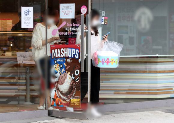 정부의 수도권 거리두기 2.5단계 연장 조치에 더해 오는 7일부터는 낮 시간 매장 내 취식이 가능했던 파리바게뜨, 던킨도너츠, 배스킨라빈스, 설빙 등 프랜차이즈형 제과제빵·아이스크림·빙수점도 다른 카페 등과 마찬가지로 포장과 배달만 허용된다. 6일 경기 하남의 한 프랜차이즈 아이스크림 판매점에서 시민들이 포장한 아이스크림을 들고 가게를 나서고 있다. 2020.9.6  연합뉴스