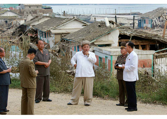 북한 김정은 국무위원장이 태풍 ‘마이삭’으로 피해를 입은 함경남도 지역에서 당중앙위원회 정무국 확대회의를 소집했다고 노동신문이 6일 전했다. 사진은 김 위원장이 피해 현장에서 당 간부 등과 이야기를 나누는 모습. 노동신문 홈페이지 캡처 연합뉴스