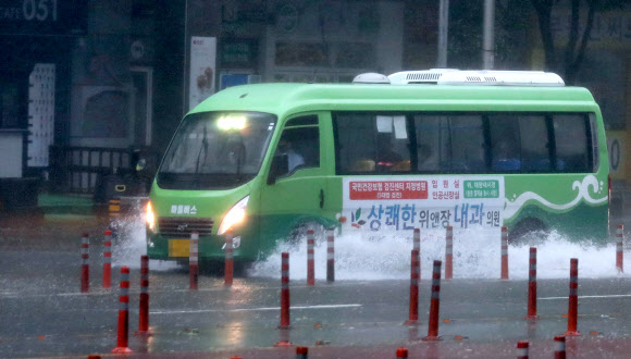 제10호 태풍 ‘하이선’이 부산에 접근 중인 7일 오전 부산 해운대구 센텀시티에서 출근하는 시민을 태운 마을버스가 침수된 도로를 지나고 있다. 2020.9.7  연합뉴스
