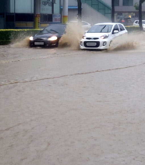 7일 오전 강원 강릉시내 도로가 폭우로 물에 잠겨 차량들이 서행하고 있다. 기상청은 제10호 태풍 ‘하이선’의 영향으로 영동지역에 최고 400㎜ 이상 비가 내릴 것으로 예보했다. 2020.9.7  연합뉴스