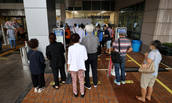 단체행동을 잠정 중단하고 업무에 복귀하기로 했던 전공의들이 계속해서 집단휴진을 이어가고 있는 7일 오전 서초구 서울성모병원에서 내원객들이 입장 전 사전 문진표를 작성하고 있다. 2020.9.7  연합뉴스