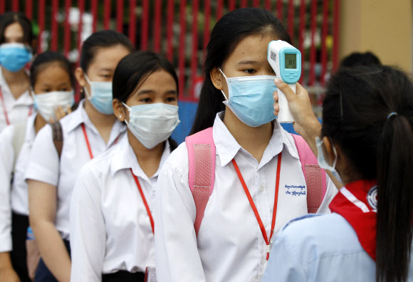 7일(현지시간) 캄보디아 프놈펜의 학교에서 등교하는 학생들이 체온 측정을 하고 있다. EPA 연합뉴스