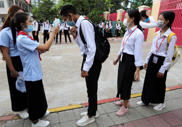 7일(현지시간) 캄보디아 프놈펜의 학교에서 등교하는 학생들이 체온 측정을 하고 있다. EPA 연합뉴스