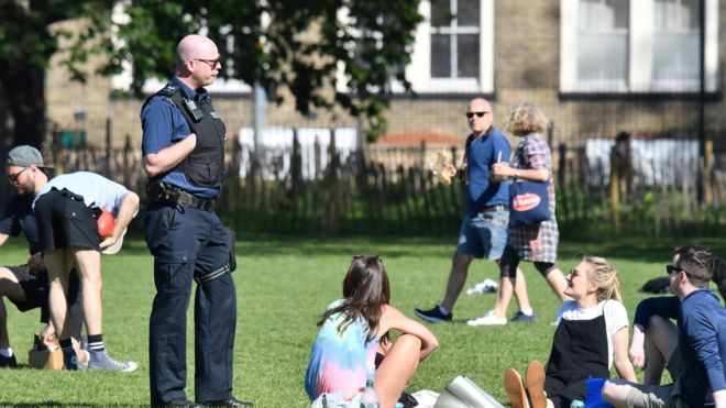 영국 잉글랜드 경찰이 한 공원에 모여 시간을 보내는 이들에게 사회적 거리 두기 규칙을 설명하고 있다. AFP 자료사진 